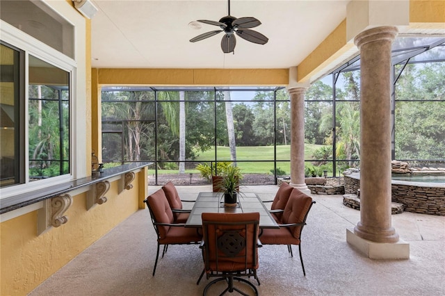 sunroom featuring ceiling fan, a healthy amount of sunlight, and ornate columns