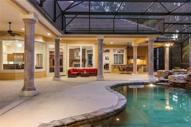 view of pool with ceiling fan, outdoor lounge area, glass enclosure, and a patio area