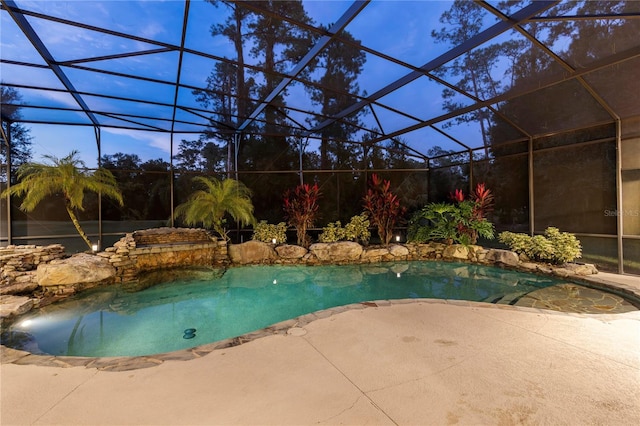 view of swimming pool with glass enclosure and a patio area