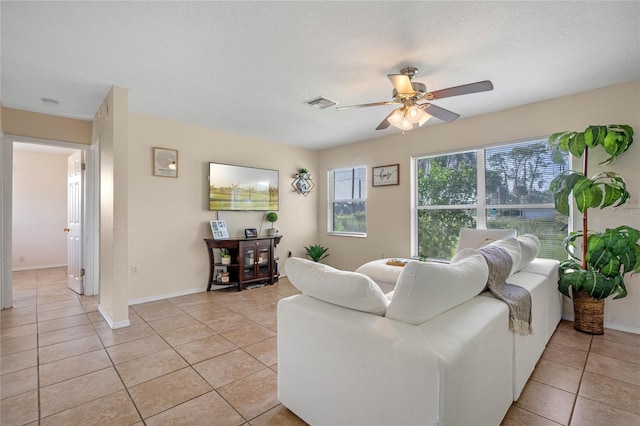 living room with ceiling fan, light tile patterned floors, and a textured ceiling