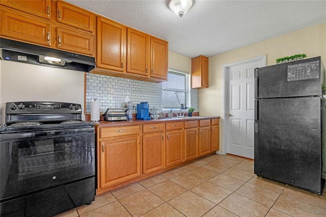 kitchen featuring backsplash, sink, light tile patterned flooring, and black appliances