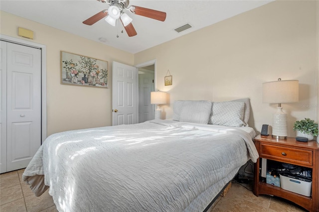 tiled bedroom with ceiling fan and a closet