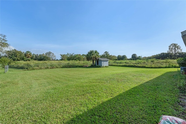 view of yard featuring a rural view and a storage unit