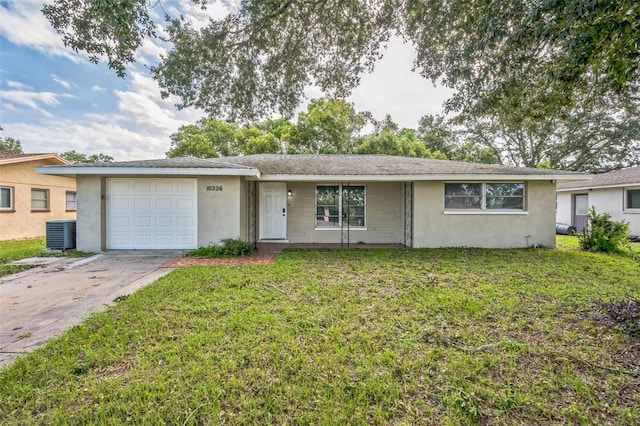 ranch-style house featuring a front lawn, central air condition unit, and a garage