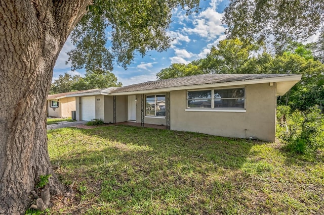 single story home featuring a front yard and a garage