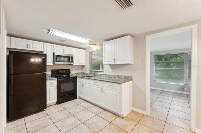 kitchen featuring white cabinets, black appliances, and light tile patterned floors