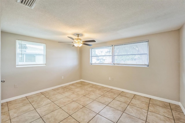 unfurnished room with ceiling fan, plenty of natural light, and a textured ceiling