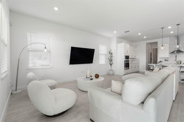 living room with light hardwood / wood-style flooring and sink