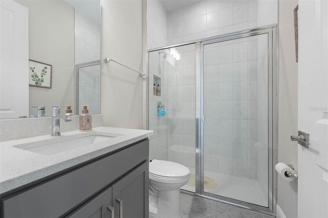 bathroom with vanity, toilet, and a shower with shower door