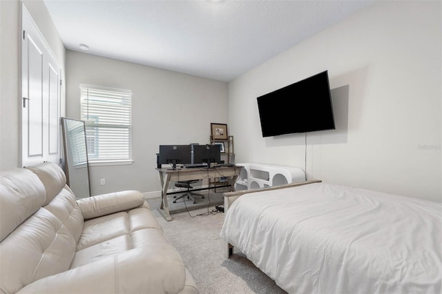 bedroom with light colored carpet and a textured ceiling