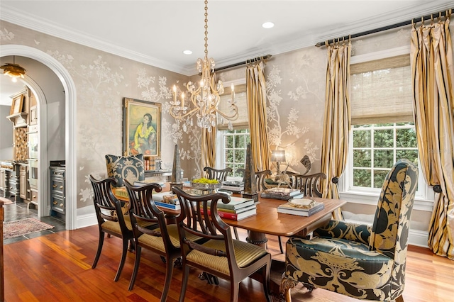 dining area with ornamental molding, wood-type flooring, and a healthy amount of sunlight