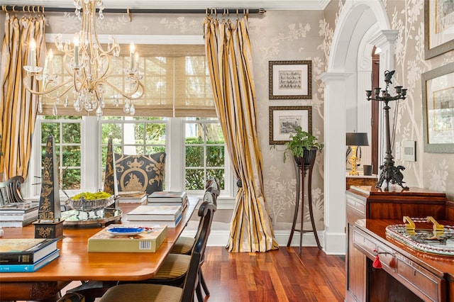 dining area with ornamental molding, a chandelier, and dark wood-type flooring