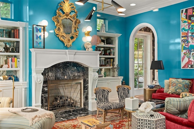 living area with ornamental molding, a premium fireplace, and a healthy amount of sunlight