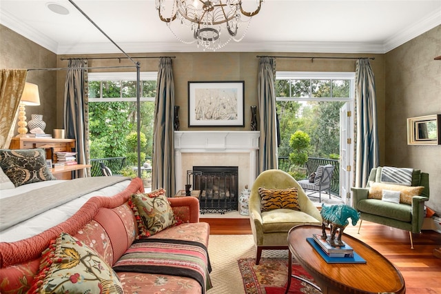 living room featuring wood-type flooring, a notable chandelier, and ornamental molding