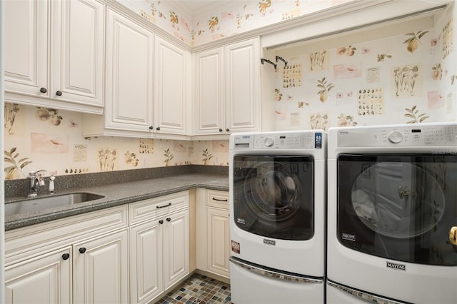 clothes washing area featuring cabinets, sink, and washing machine and clothes dryer