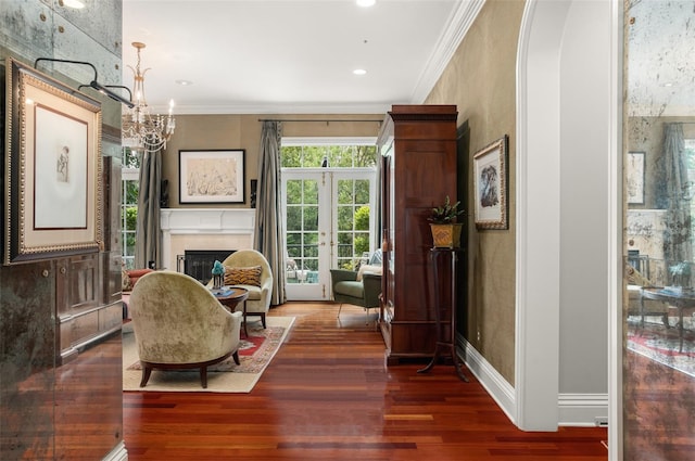 sitting room with crown molding, dark hardwood / wood-style floors, a chandelier, and french doors