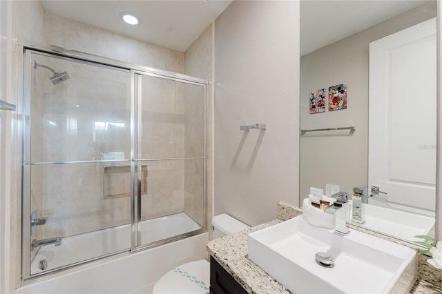 full bathroom featuring vanity, toilet, and bath / shower combo with glass door