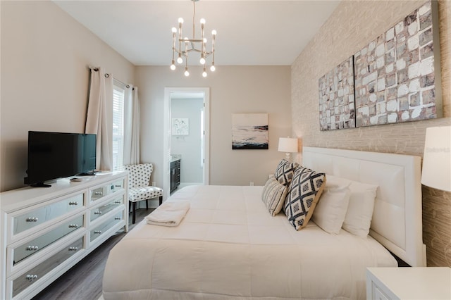 bedroom with an inviting chandelier, dark wood-type flooring, and connected bathroom