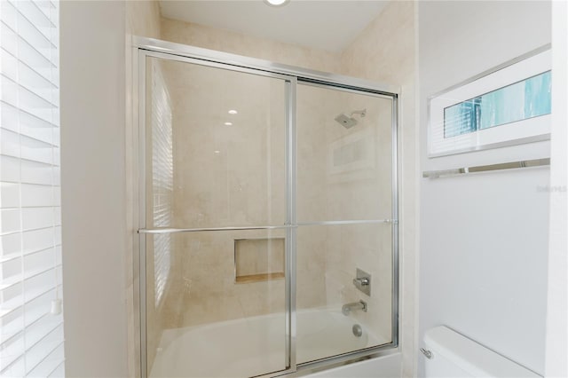 bathroom featuring toilet and enclosed tub / shower combo