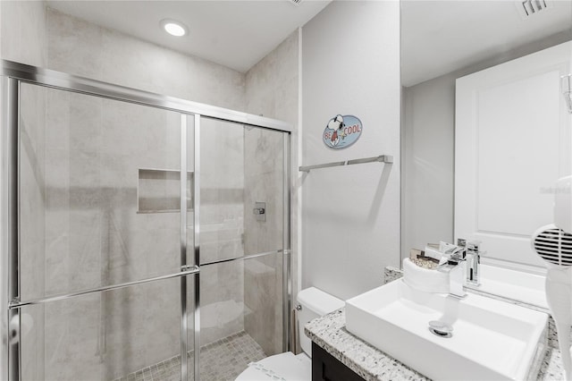 bathroom featuring vanity, toilet, and an enclosed shower