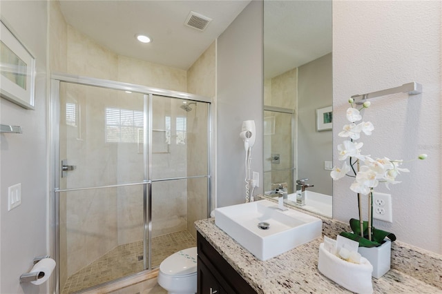 bathroom with vanity, toilet, and an enclosed shower