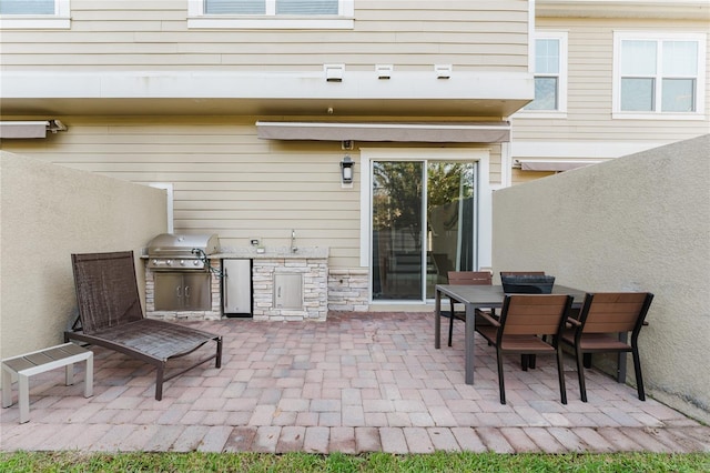 view of patio / terrace featuring area for grilling, sink, and a grill