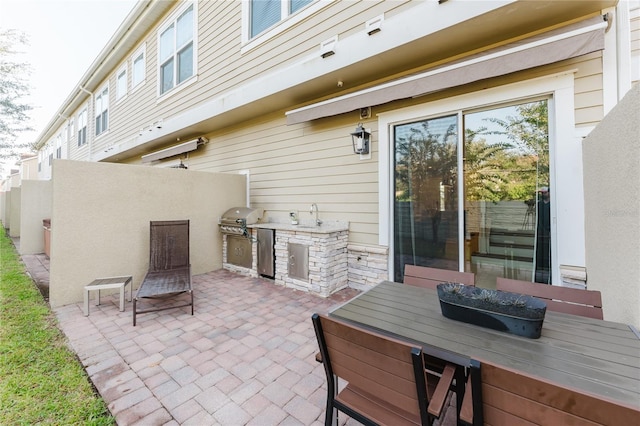 view of patio with an outdoor kitchen, sink, and grilling area