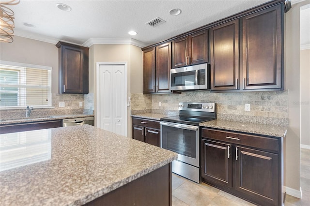 kitchen featuring backsplash, appliances with stainless steel finishes, dark brown cabinetry, and sink