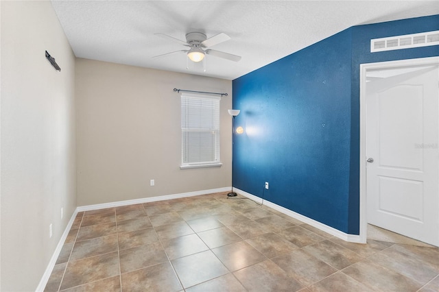 tiled spare room with ceiling fan and a textured ceiling