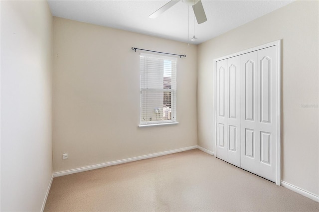 unfurnished bedroom with ceiling fan, light colored carpet, and a closet