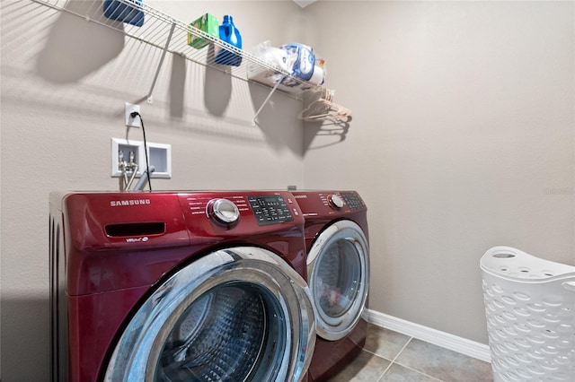 laundry room with washer and clothes dryer and light tile patterned floors