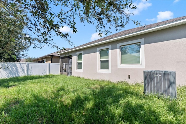 view of property exterior featuring central AC unit and a yard