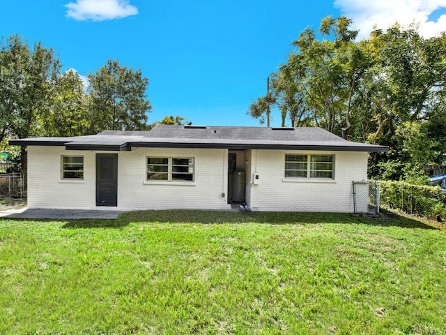 rear view of property featuring a yard and a patio area