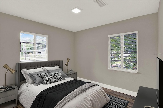 bedroom featuring dark wood-type flooring and multiple windows