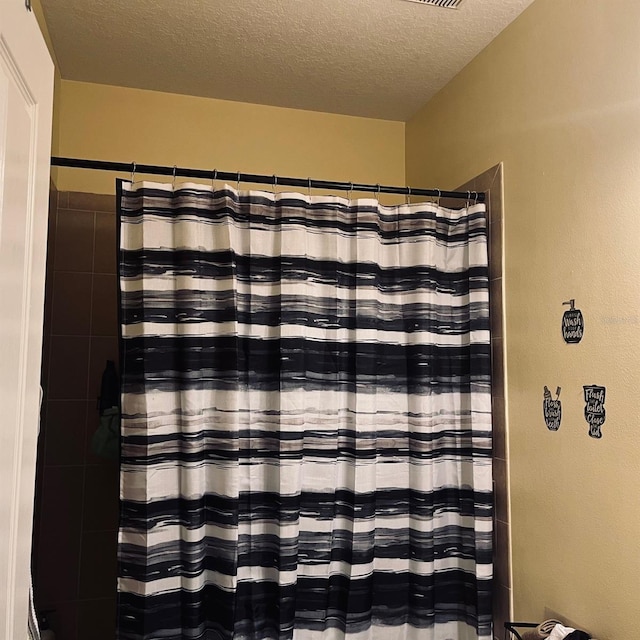 bathroom featuring a textured ceiling and walk in shower