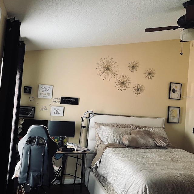 bedroom with ceiling fan and a textured ceiling