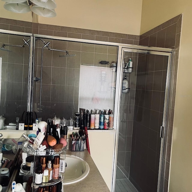 bathroom featuring a shower with door and vanity