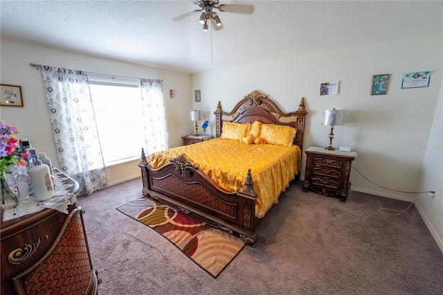 bedroom with dark colored carpet, a textured ceiling, and ceiling fan