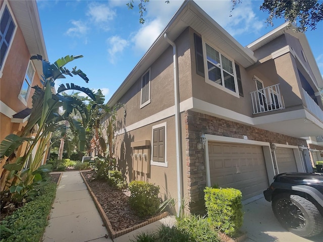 view of side of property with a balcony and a garage