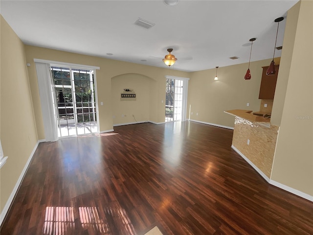 unfurnished living room with ceiling fan and dark wood-type flooring