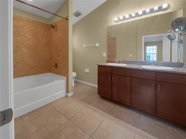 full bathroom featuring tiled shower / bath, vanity, toilet, tile patterned floors, and vaulted ceiling