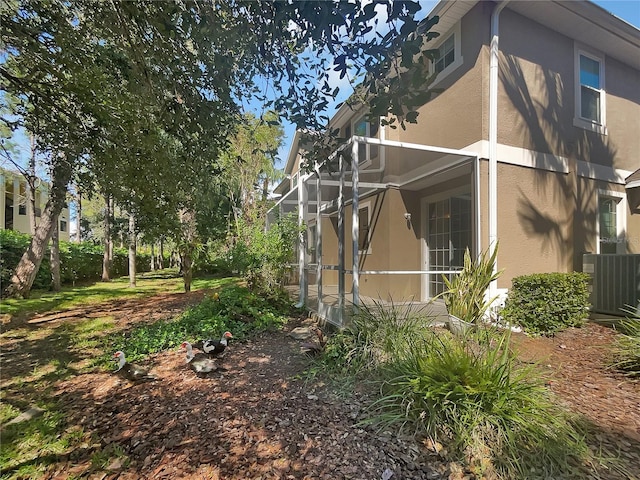 view of side of home featuring a lanai and central AC unit