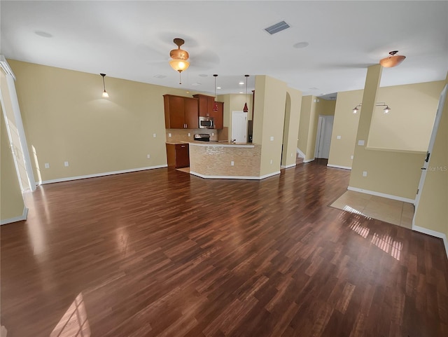 unfurnished living room featuring dark hardwood / wood-style floors and ceiling fan