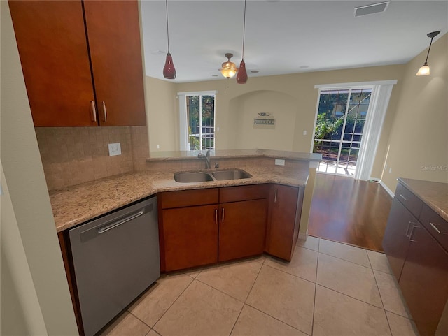 kitchen with kitchen peninsula, dishwasher, light tile patterned floors, and sink