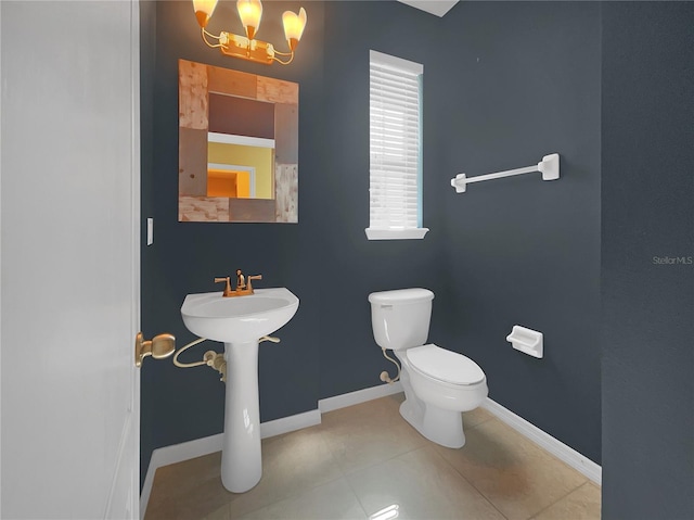 bathroom featuring a notable chandelier, tile patterned flooring, and toilet