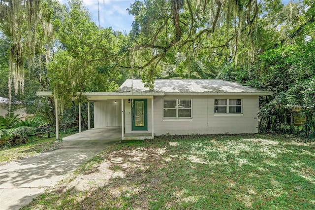 ranch-style house featuring a carport and a front yard