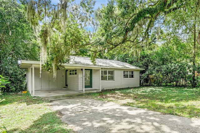 single story home featuring a front lawn and a carport