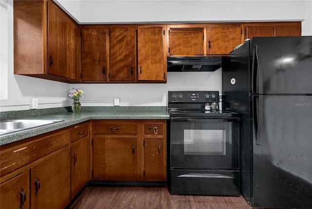 kitchen with black appliances and dark hardwood / wood-style flooring