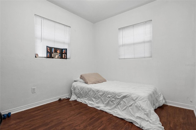 bedroom with dark hardwood / wood-style floors