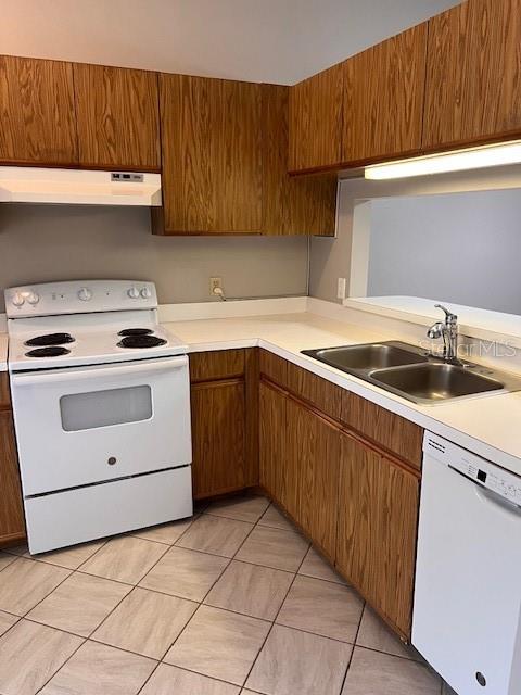 kitchen featuring white appliances, exhaust hood, light tile patterned floors, and sink